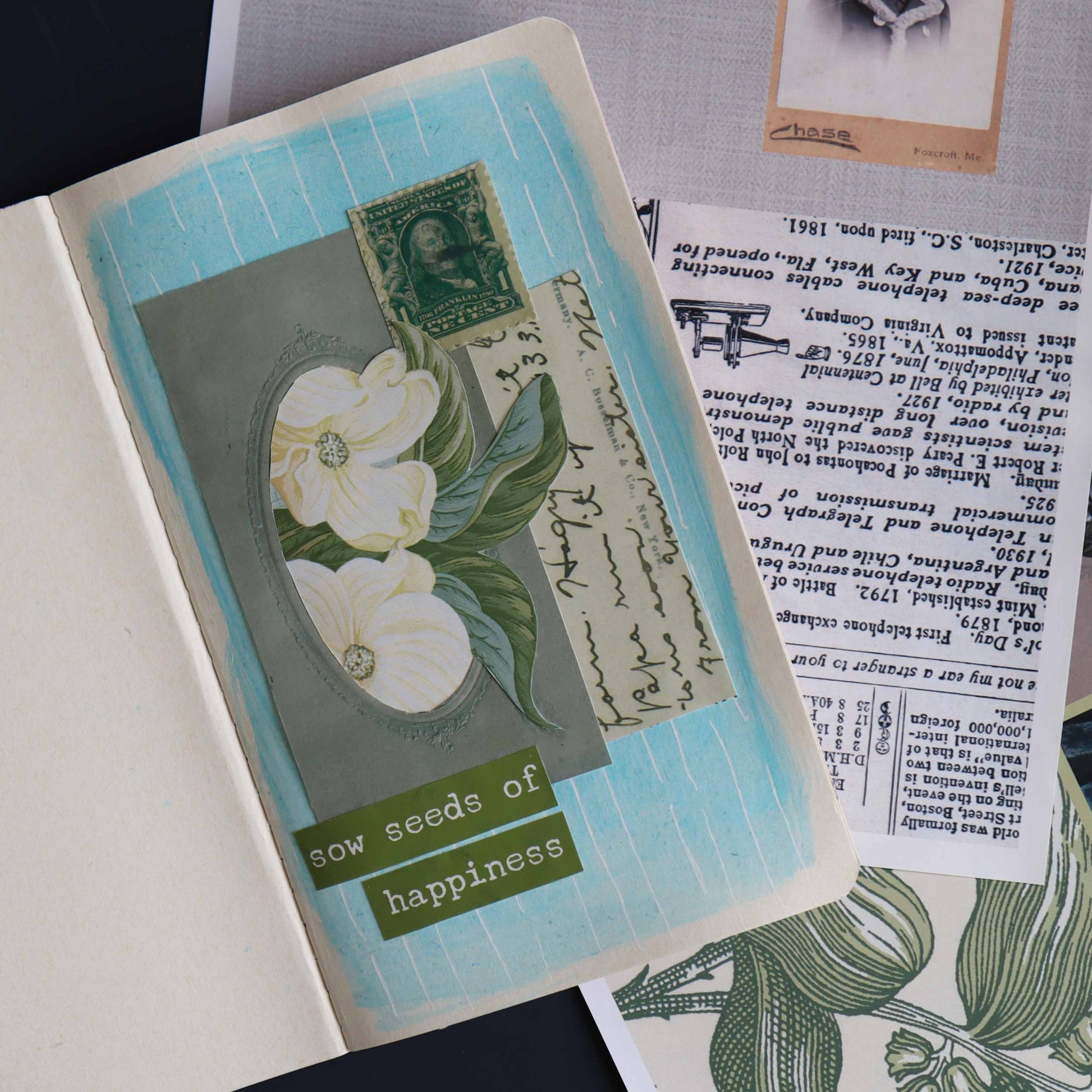 Mixed media art project in a notebook on top of additional sheets of collage paper